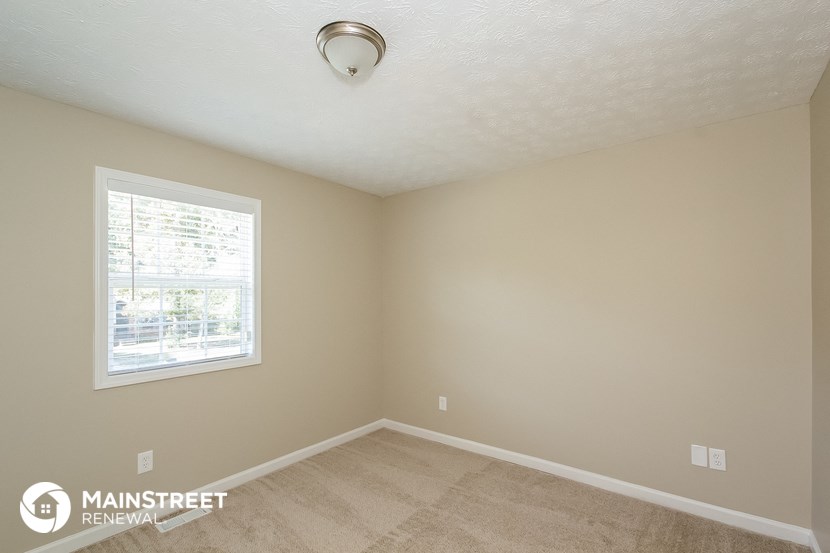 the interior of a bedroom with carpet and a window