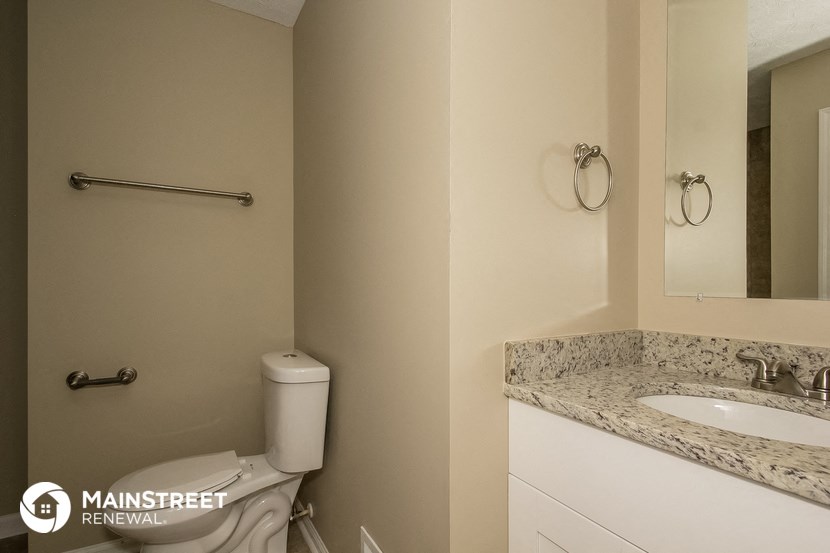 a bathroom with a toilet and a sink and a mirror