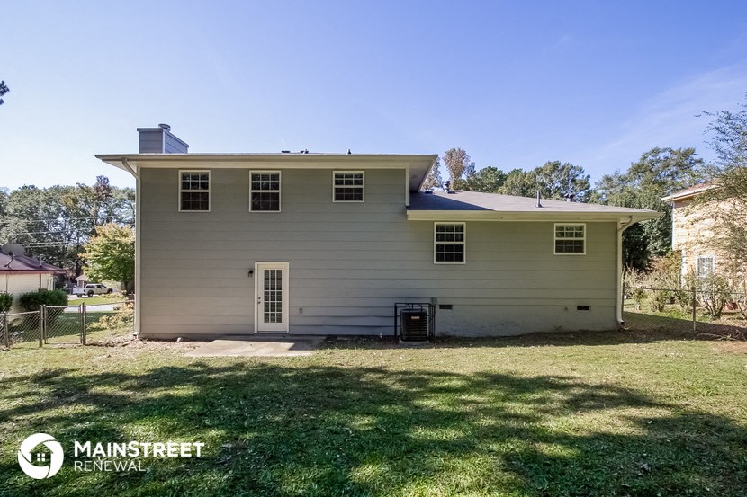 the front of a white house with a yard and grass
