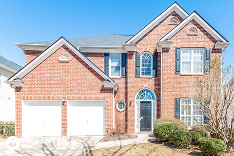 a brick house with two garage doors in front of it