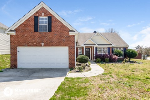 a brick house with a white garage door and a lawn