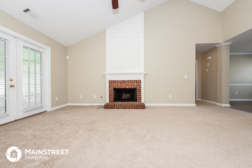 a empty living room with a fireplace and a door