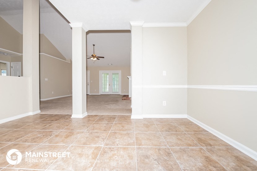 the living room and dining room with the kitchen in the background
