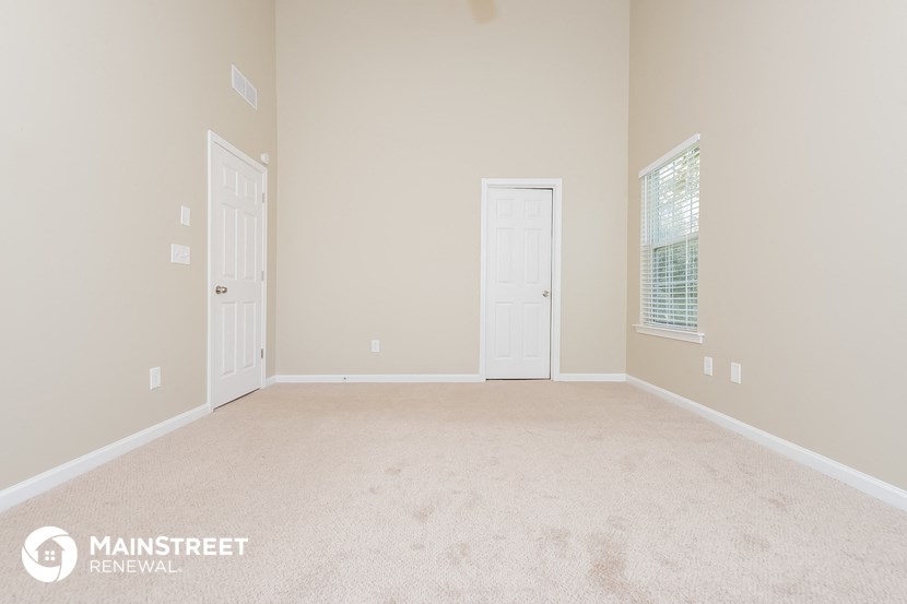 a bedroom with a carpeted floor and two doors