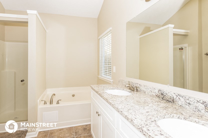 a bathroom with two sinks and a tub and a mirror