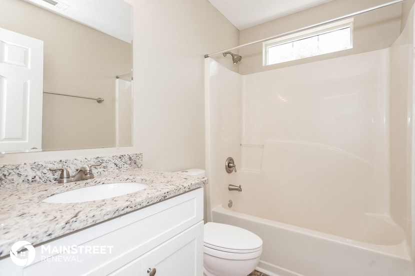 a bathroom with a toilet and a sink and a shower