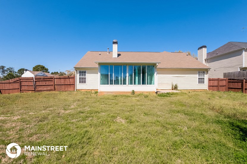 a backyard with a house and a grassy yard
