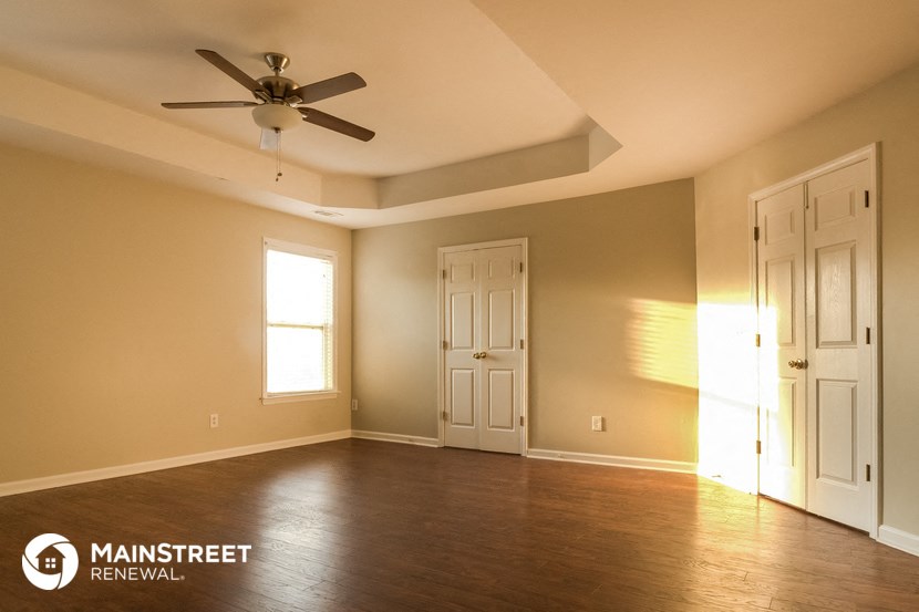 an empty living room with a ceiling fan