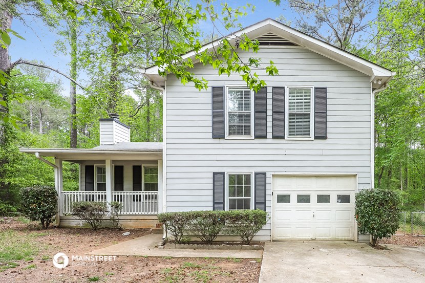 a white house with black shuttered windows and a porch