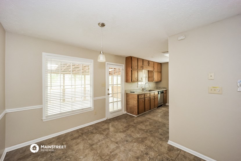 an empty kitchen with wood cabinets and a window