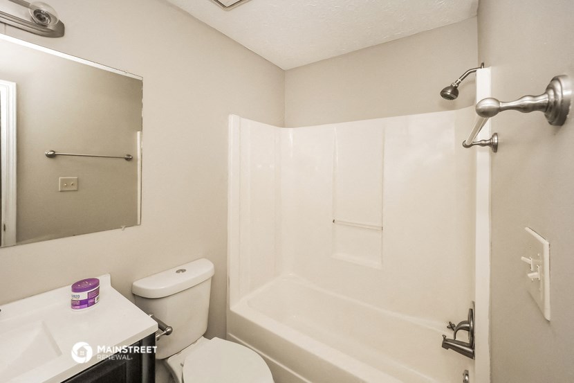 a bathroom with a shower and a toilet and a sink