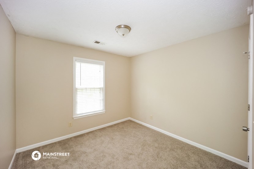 an empty room with carpet and a window