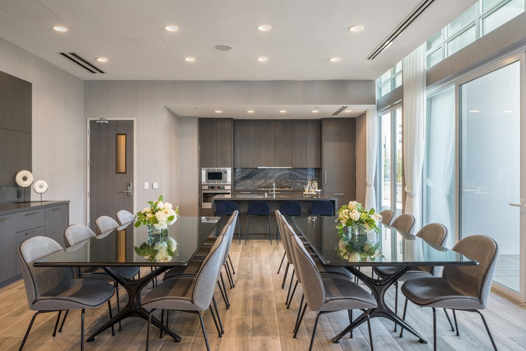 A modern dining room with a glass table and chairs.