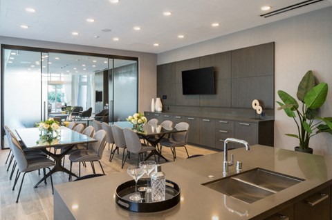 A modern kitchen with a dining table set for two.