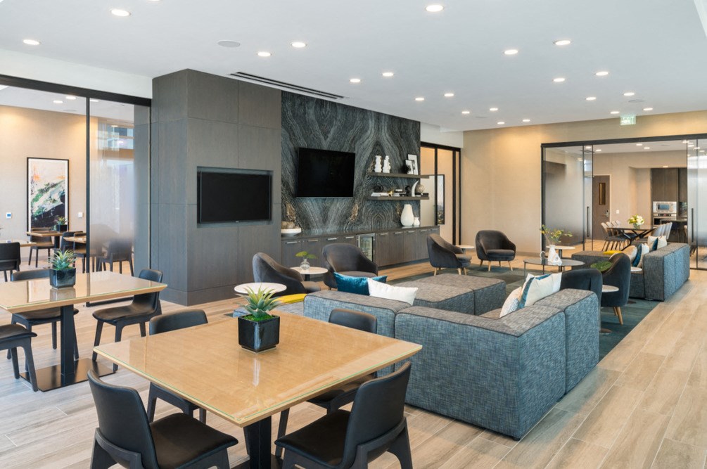 A modern living room with a wooden table and black chairs.