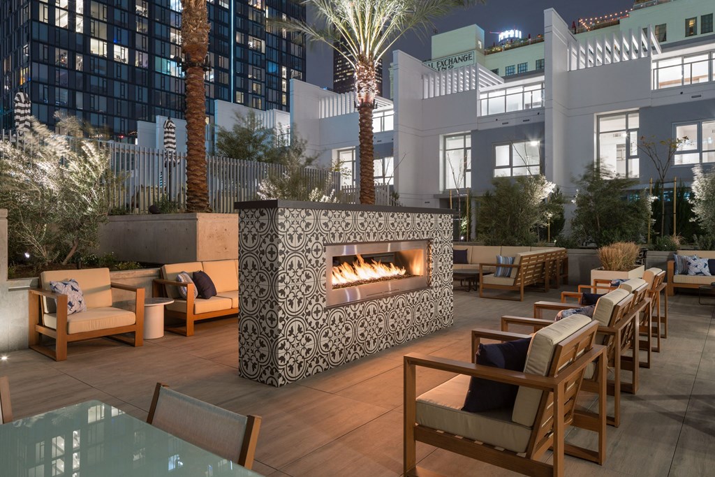 A patio with a fireplace and chairs.