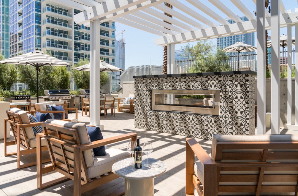 A patio with wooden furniture and a fireplace.
