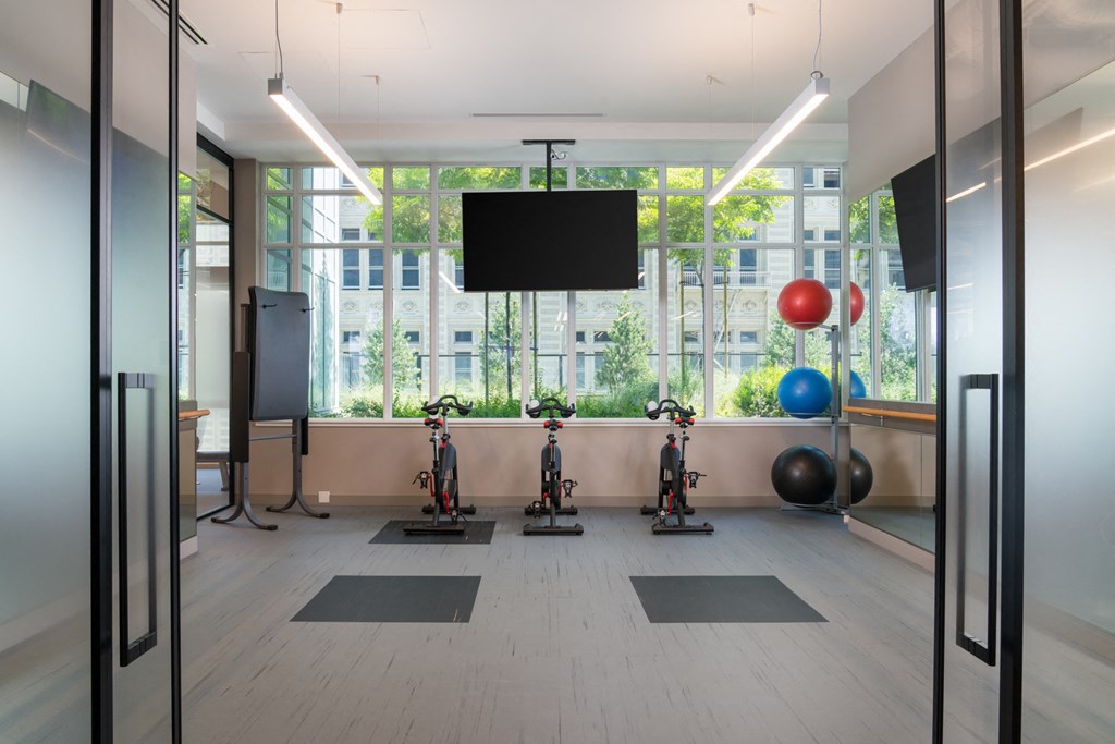 A gym with exercise equipment and a flat screen TV.