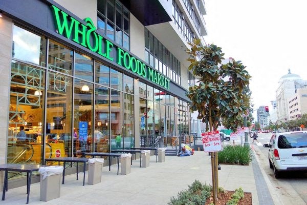 A Whole Foods Market storefront with a tree in front.