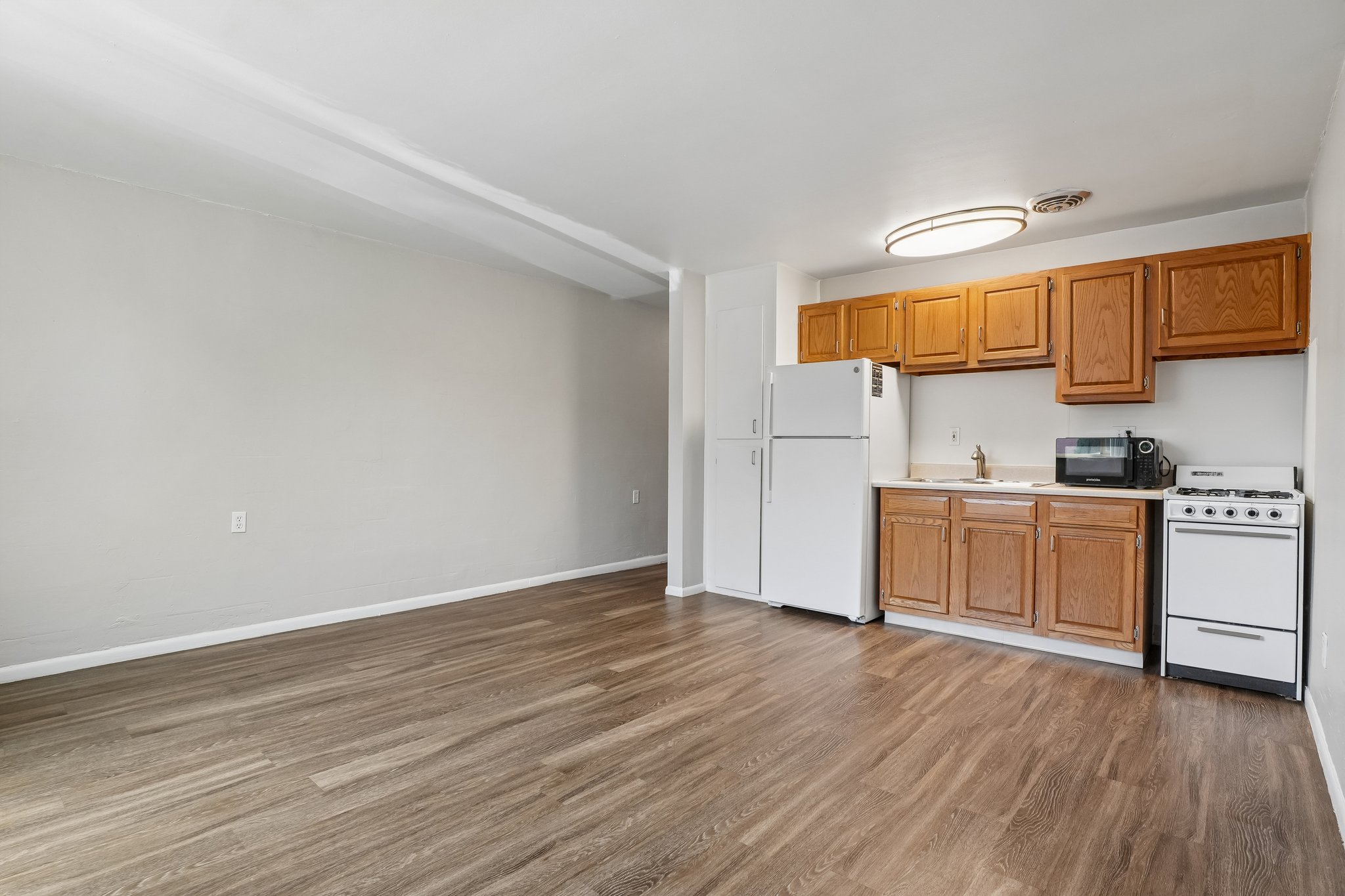 A kitchen with wooden cabinets and white appliances.