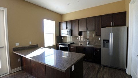 a kitchen with a granite counter top and a stainless steel refrigerator