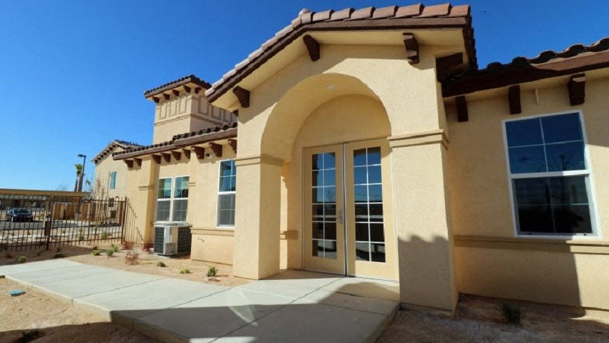 the front of a house with a sidewalk and a gate