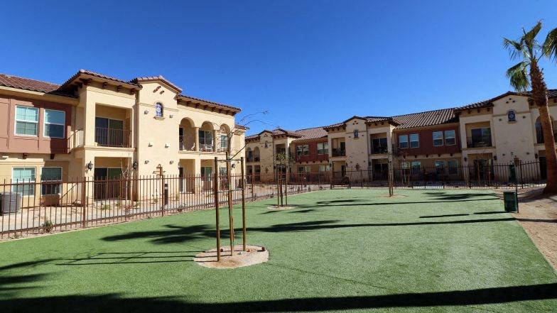 a tennis court is in front of some buildings