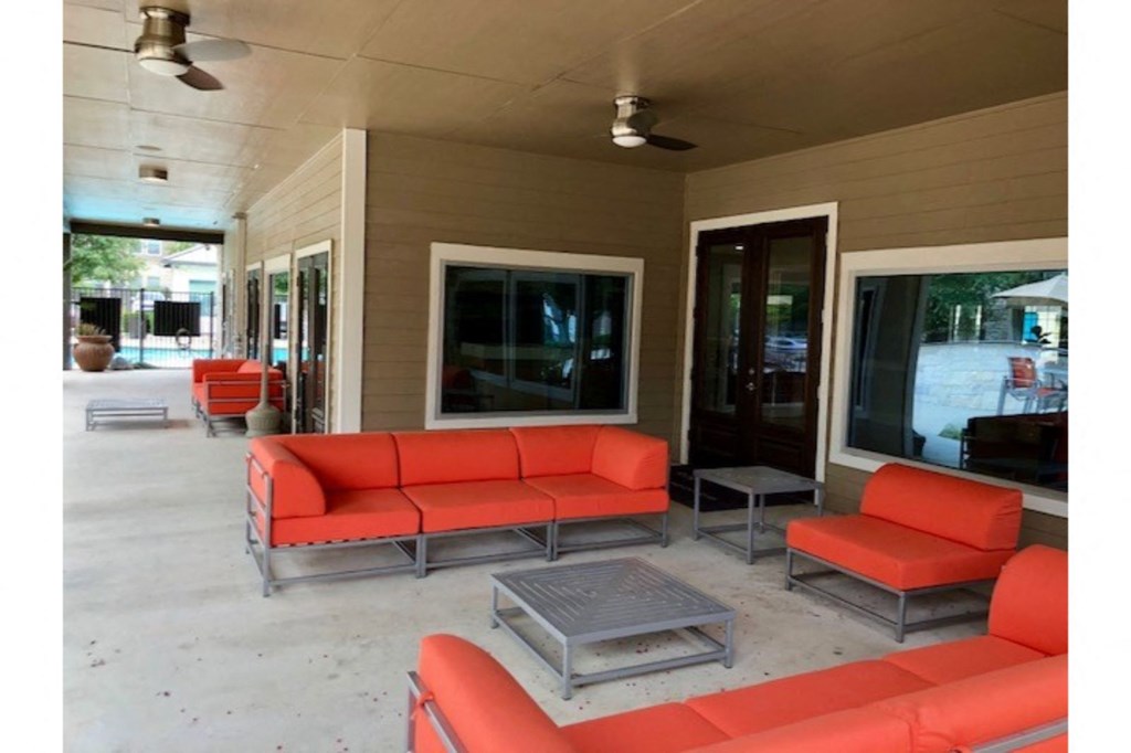 a patio with couches and tables on a porch