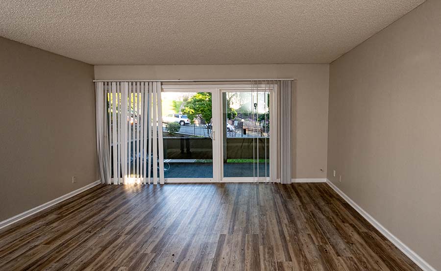 Living room with patio window  l Forest Glenn Apartments