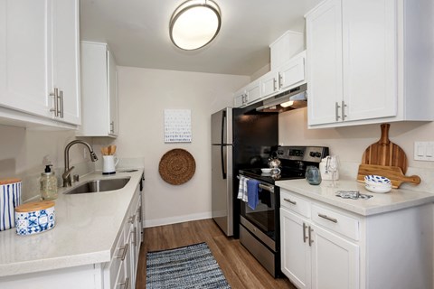 a kitchen with white cabinets and stainless steel appliances and a sink