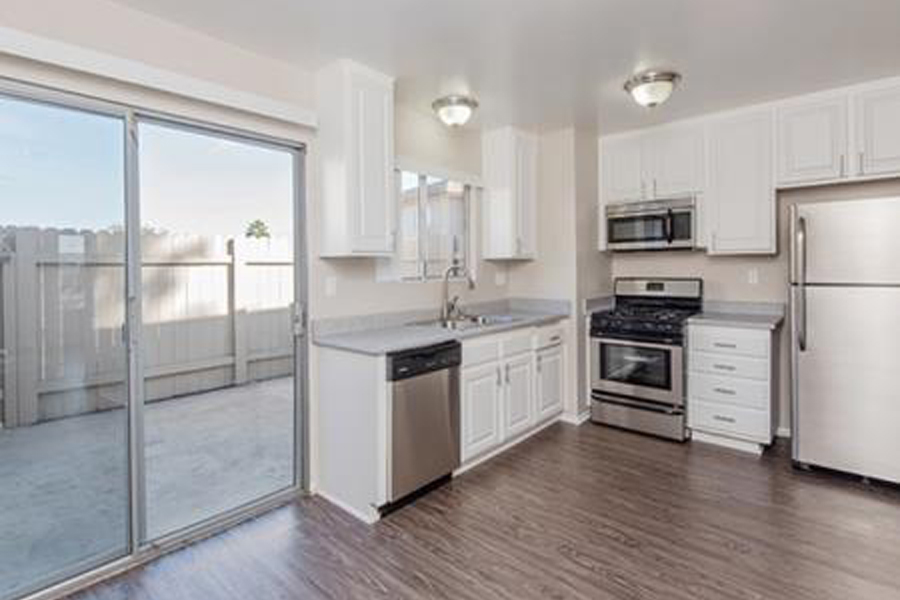 a kitchen with white cabinets and stainless steel appliances
