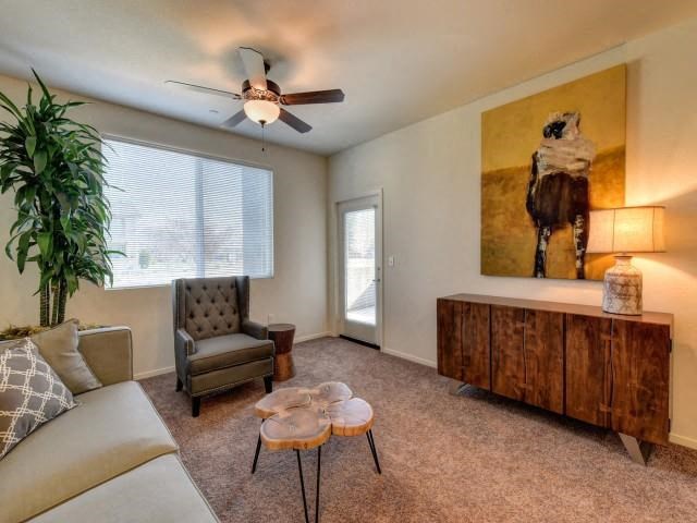 Chico Apartments for Rent-Eaton Village-Living Room with Large Windows, a Ceiling Fan, and Carpet Flooring