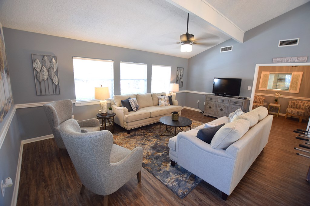 a living room with couches and chairs and a tv