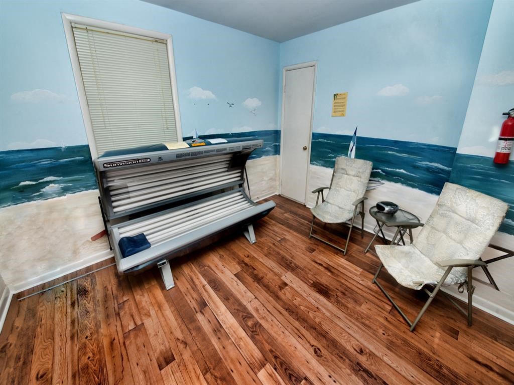 a living room with a piano and a wall mural of the ocean
