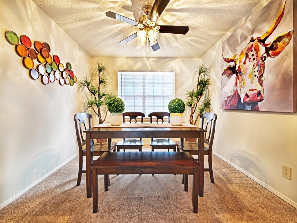 a dining room with a table and chairs and a ceiling fan