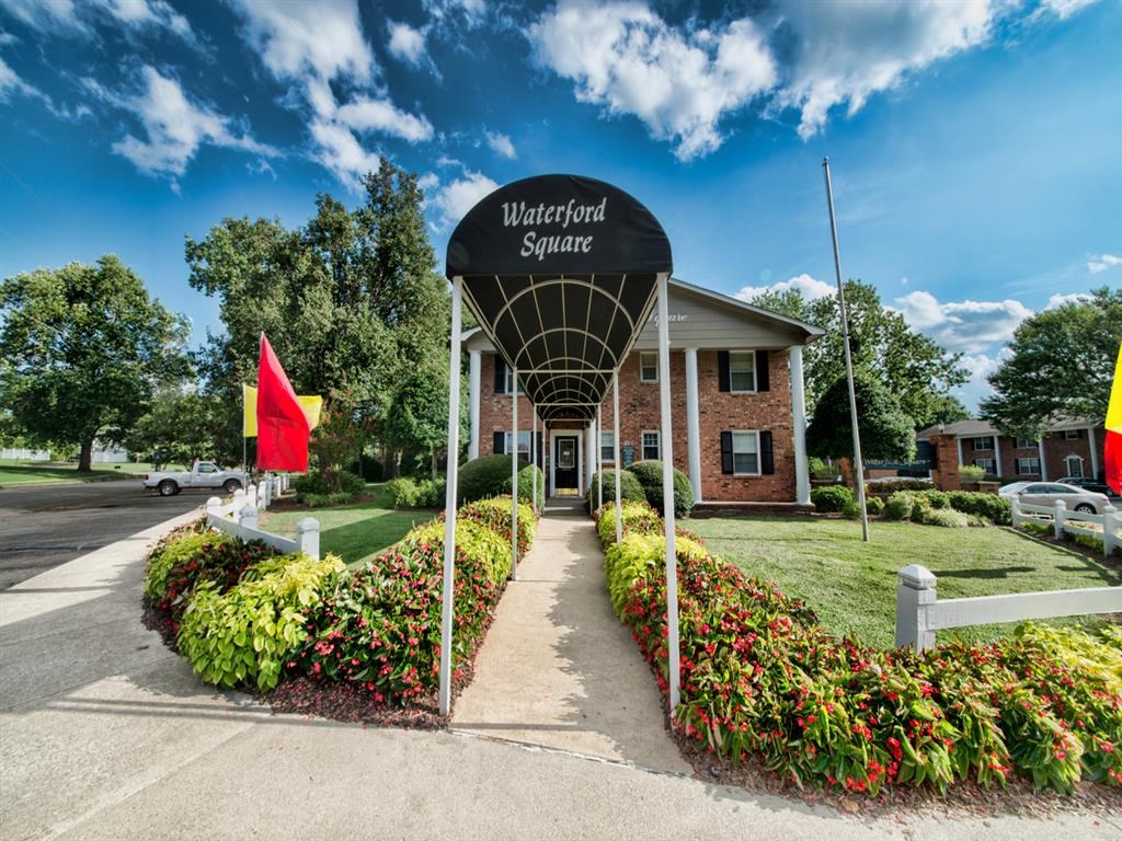 the front of the waterford square office building with a red flag and a sign