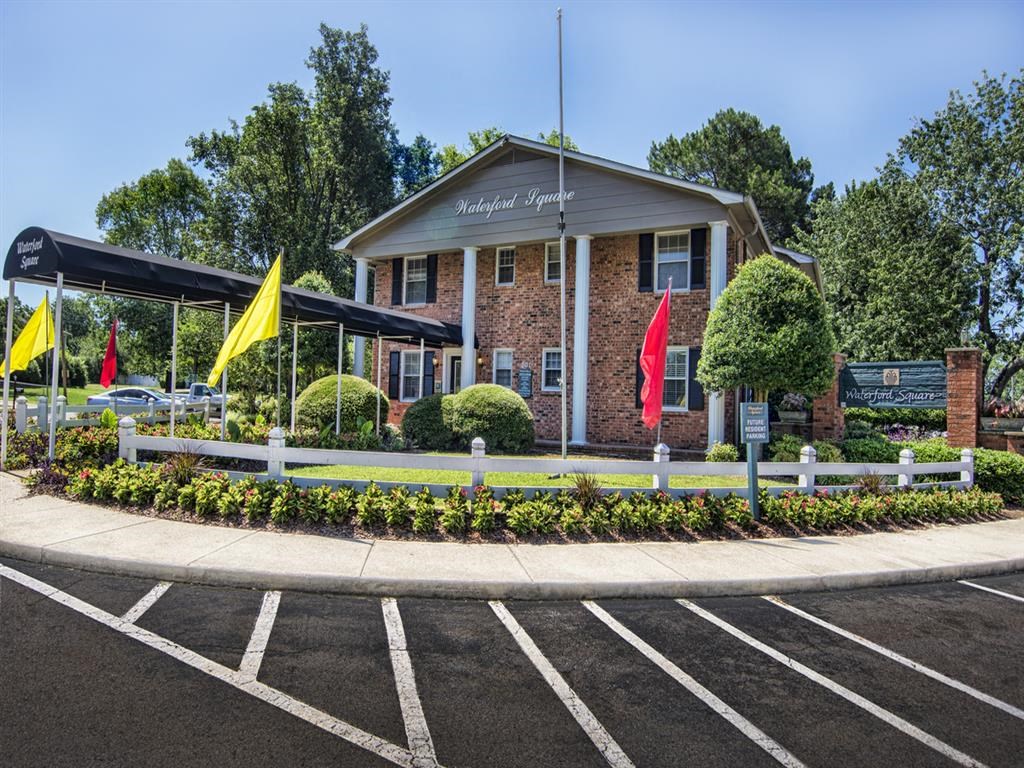 the front of a building with flags and a parking lot