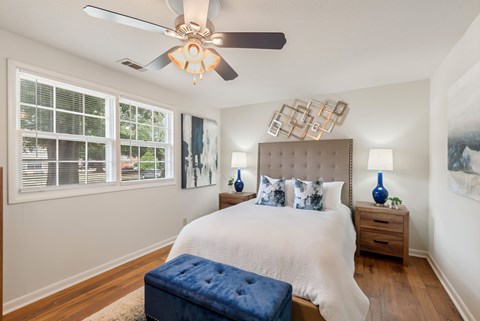 A bedroom with a large bed and a ceiling fan.