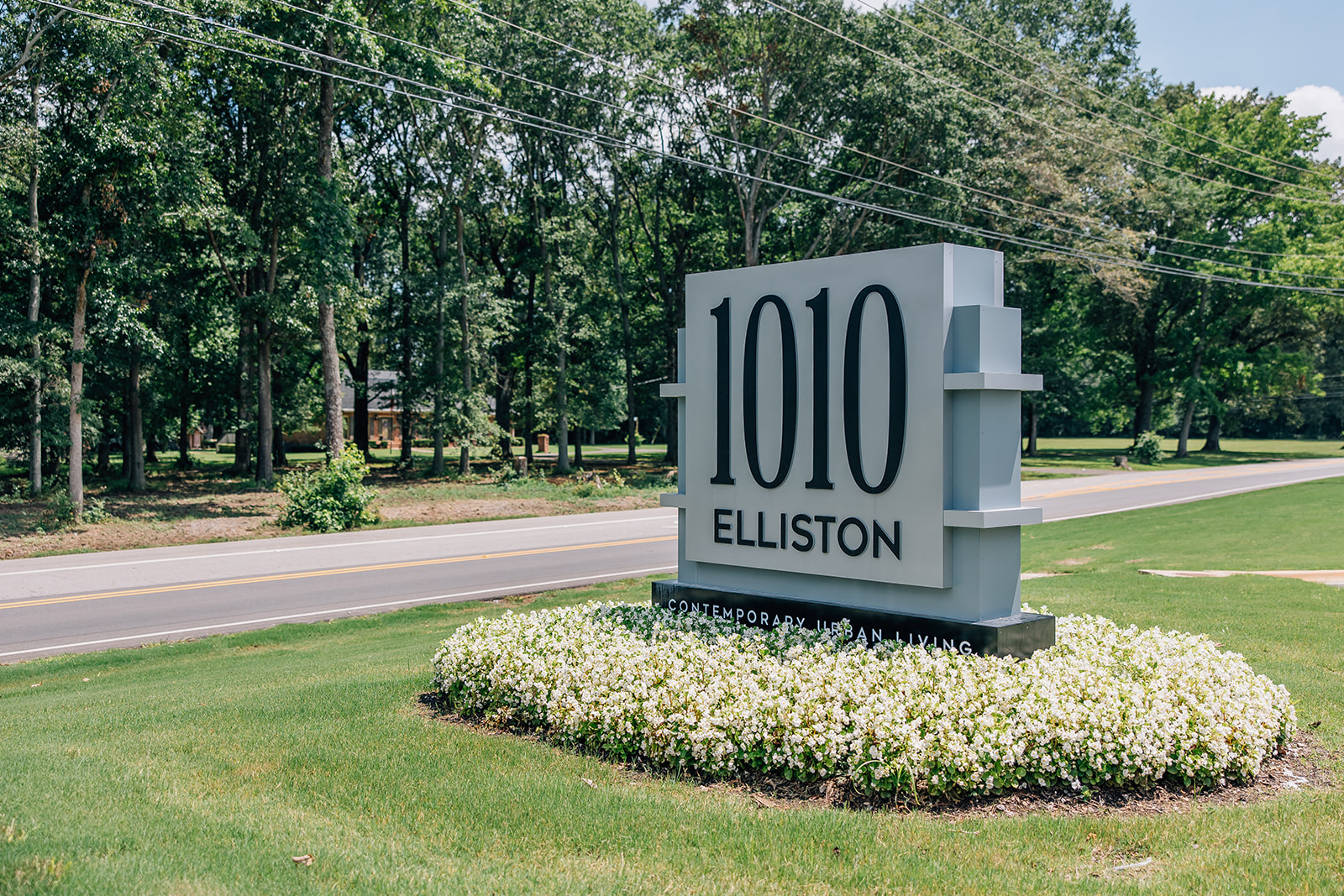A sign for Elliston stands in a flower bed.