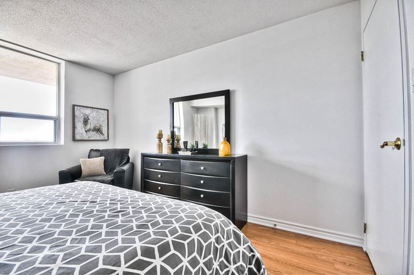 a bedroom with a bed and a dresser and a window