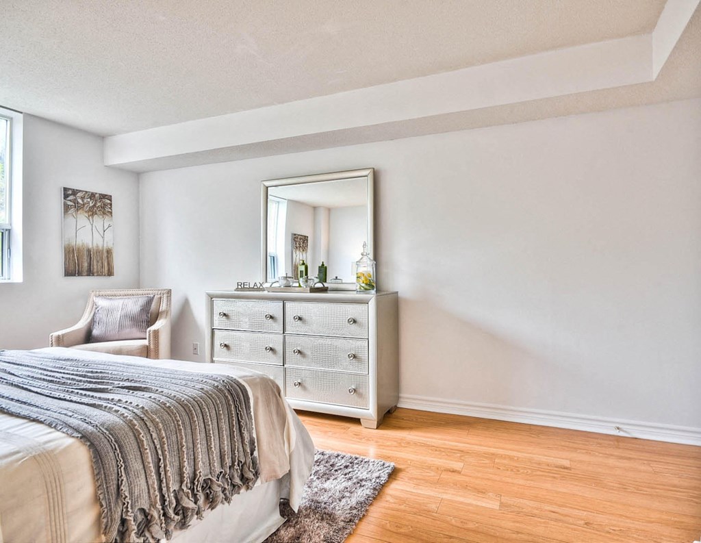 a bedroom with a bed and a dresser with a mirror