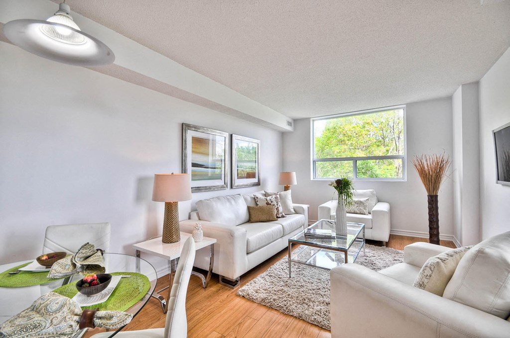 a living room with white couches and a glass table