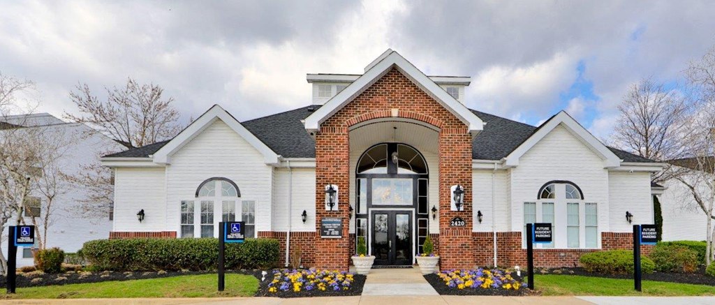 the front facade of a white house with a black door