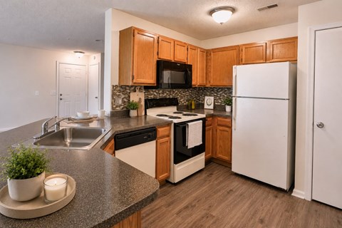 A kitchen with a white fridge and wooden cabinets.