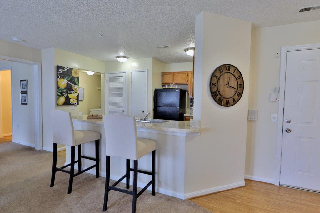 a kitchen with a bar and a clock on the wall