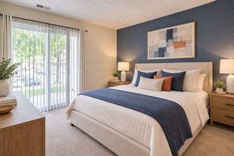 A bedroom with a large bed and a painting on the wall.