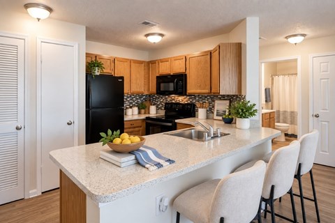 A kitchen with a granite countertop and a bowl of fruit on it.