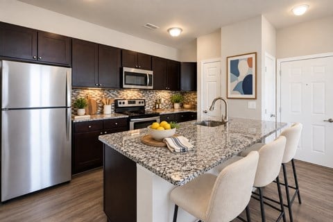 A kitchen with a granite countertop and stainless steel appliances.