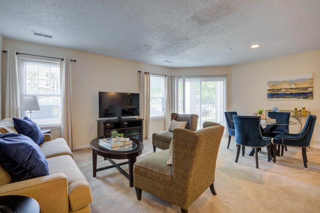 a living room with a couch and chairs and a tv