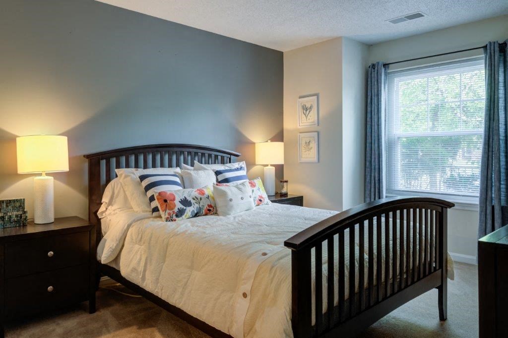 a bedroom with a bed and a crib and a window